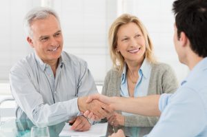 Older Happy Couple Shaking Hand With Financial Adviser